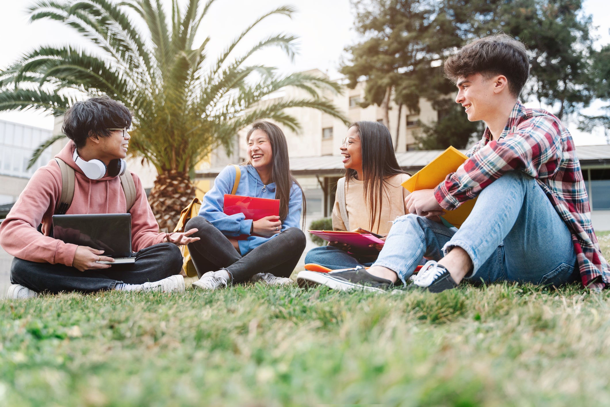 international students sitting on grass talking