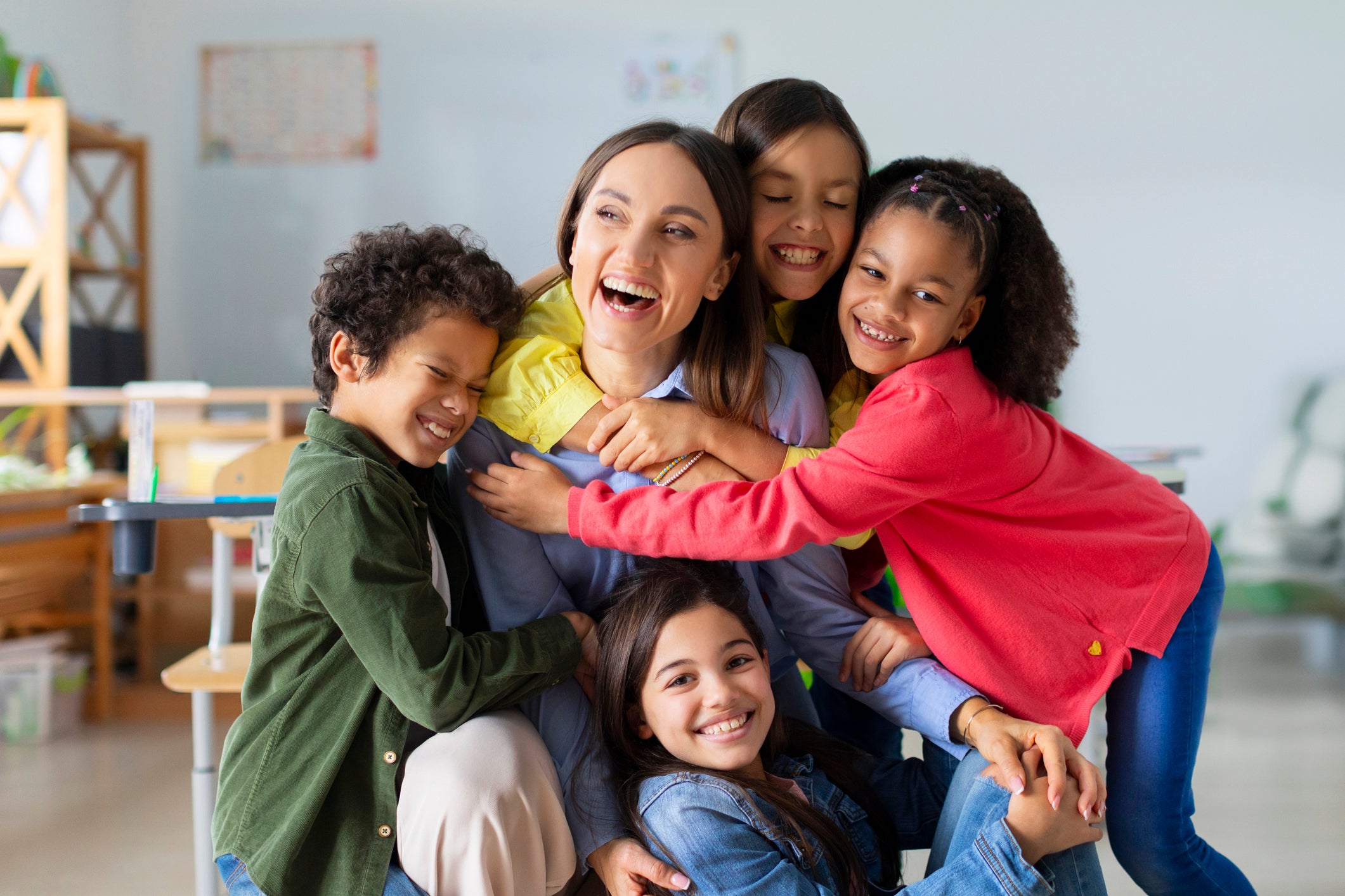 students hugging teacher