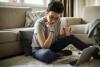 woman looking at laptop holding coffee