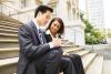 two lawyers sitting on steps looking at notepad