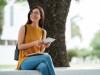 woman holding tablet sitting on ledge