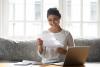 happy woman holding paper reading good news