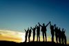 group of people holding hands in sunset