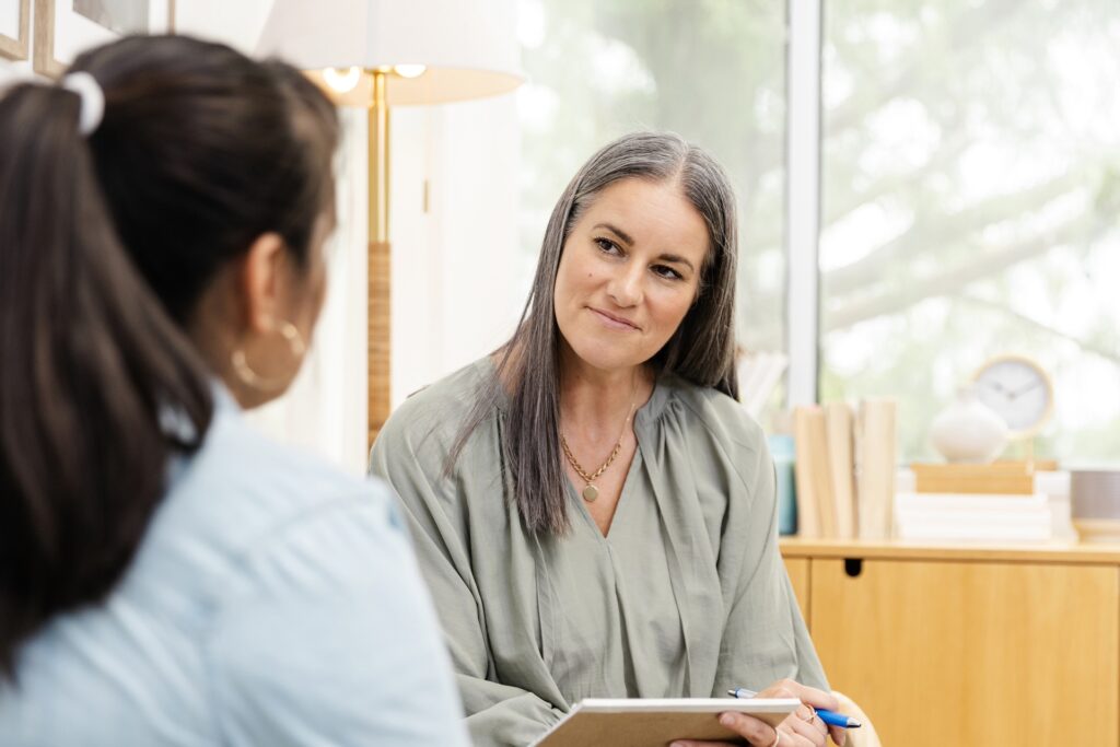 Female counselor listens non-judgmentally to unrecognizable female client
