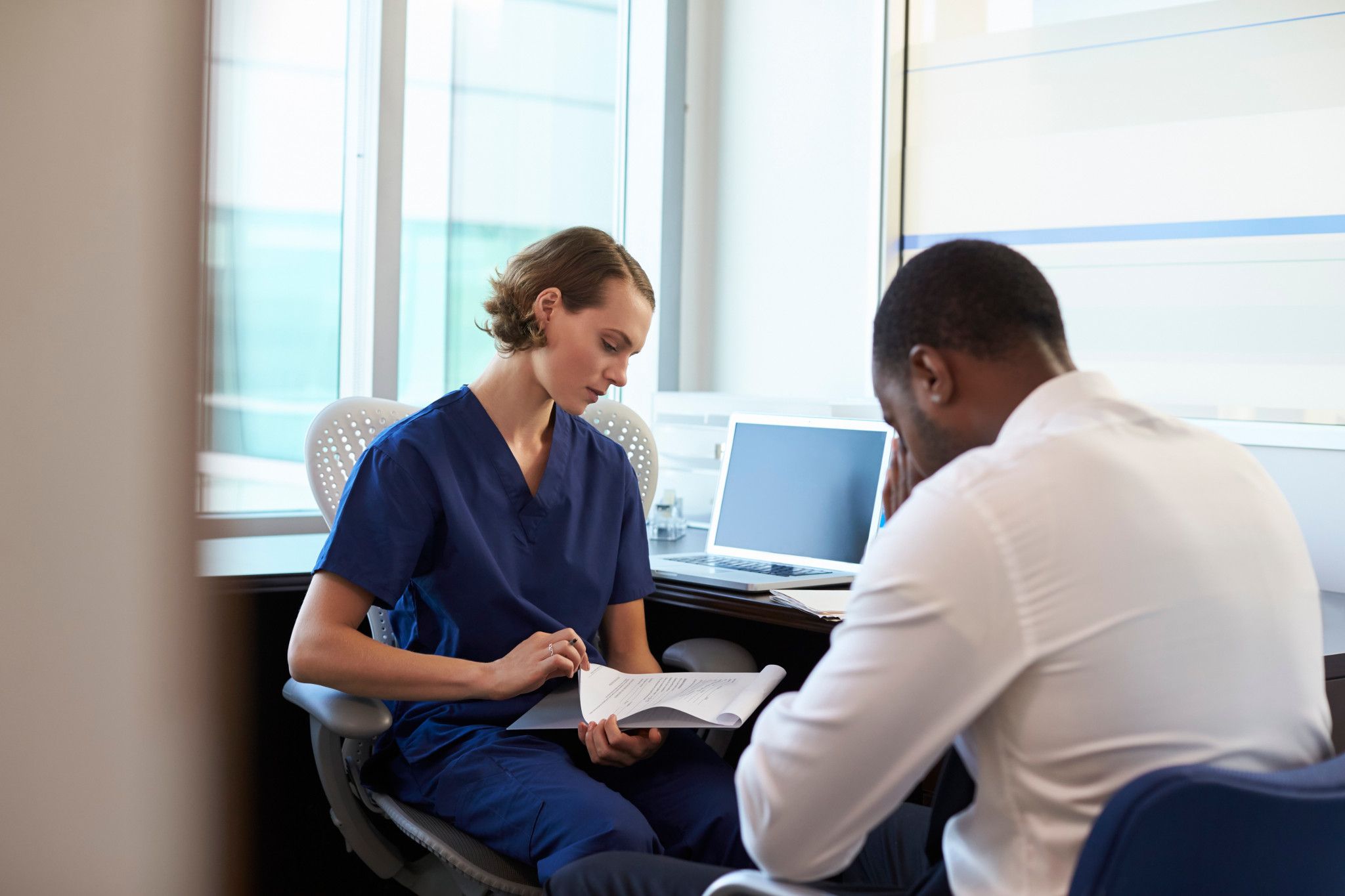 woman with a clinical psychology graduate program credentials reviewing records with patient