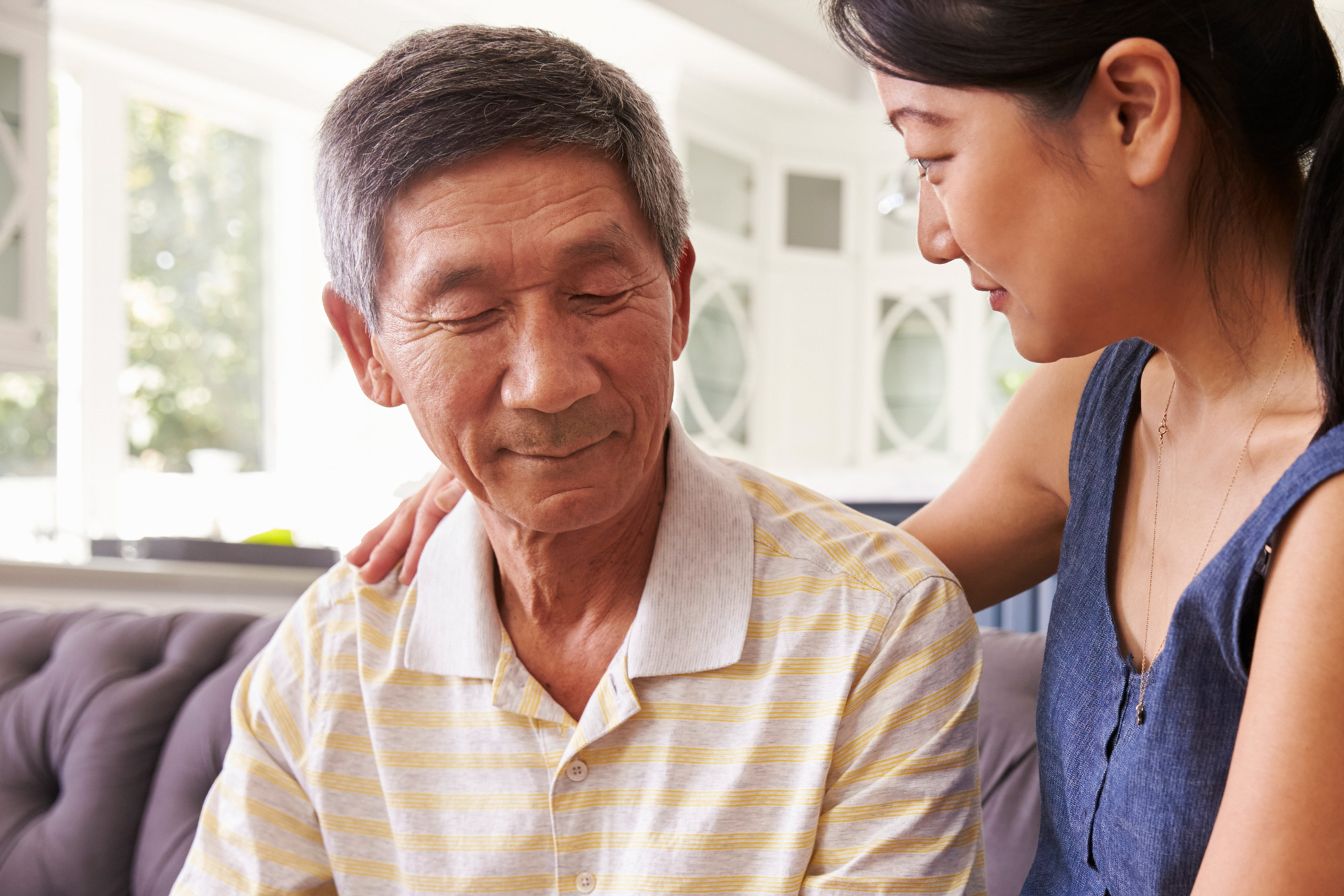 adult daughter talking to depressed father at home