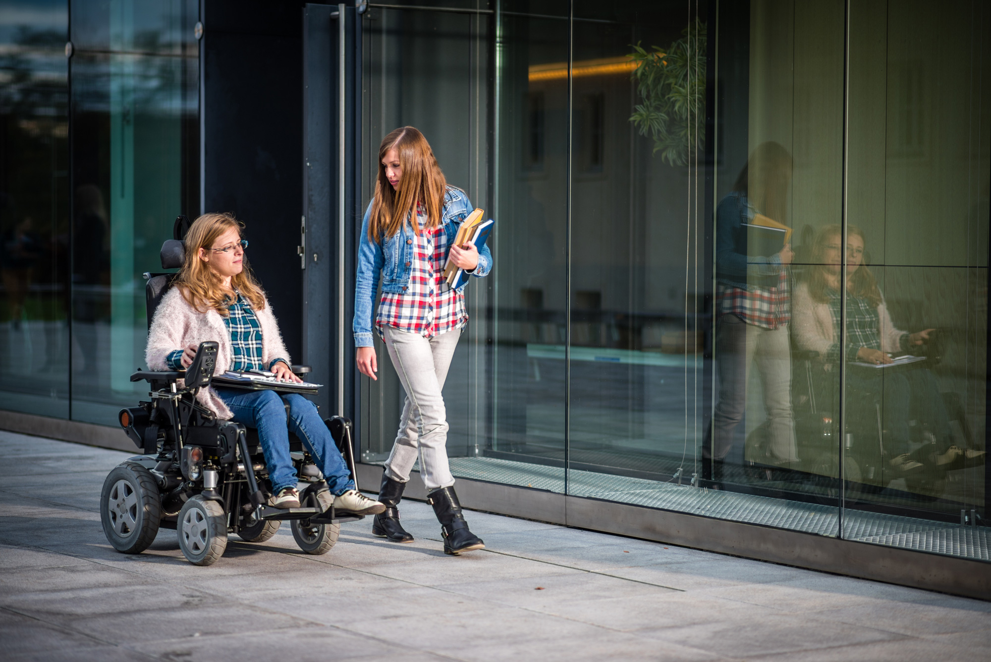 woman in wheelchair strolls with another woman