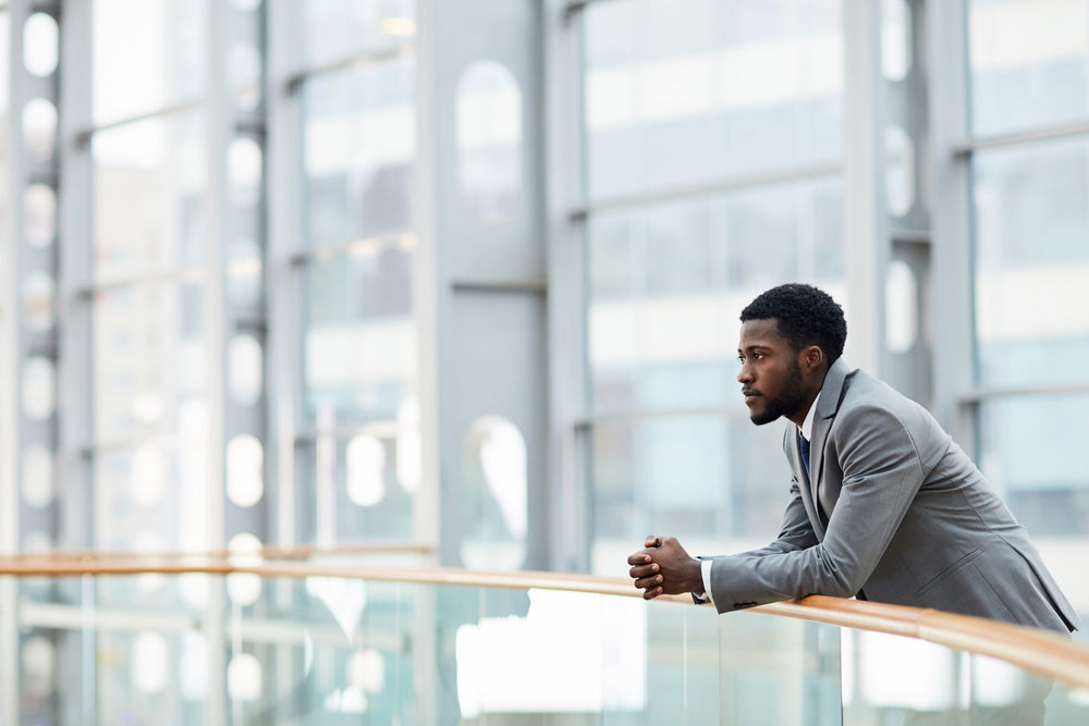 man standing and looking over balcony