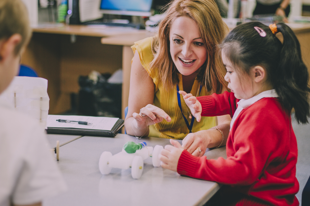 female teacher after receiving her degree to become a teacher with a young girl