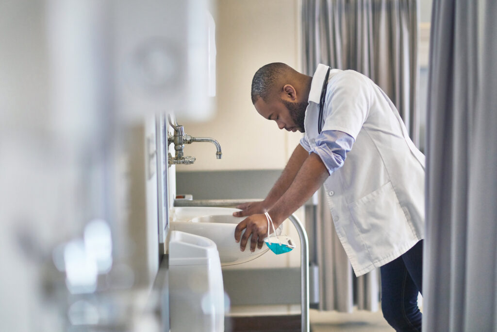 healthcare worker leaning over a sink