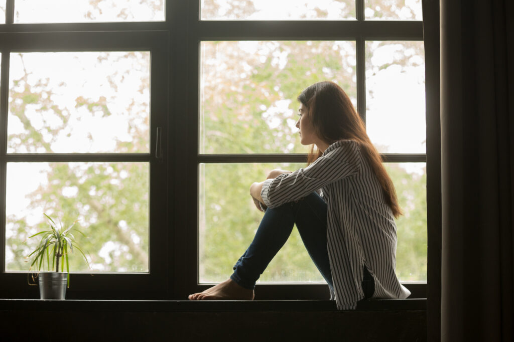 woman sitting staring out window