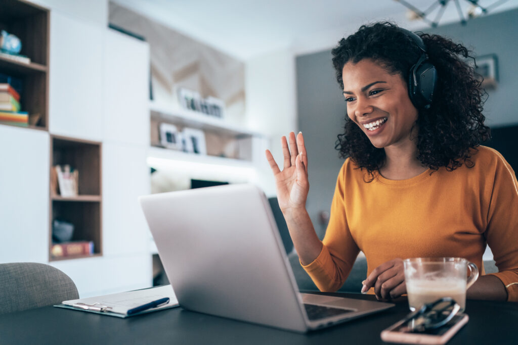 woman waving at laptop during meeting