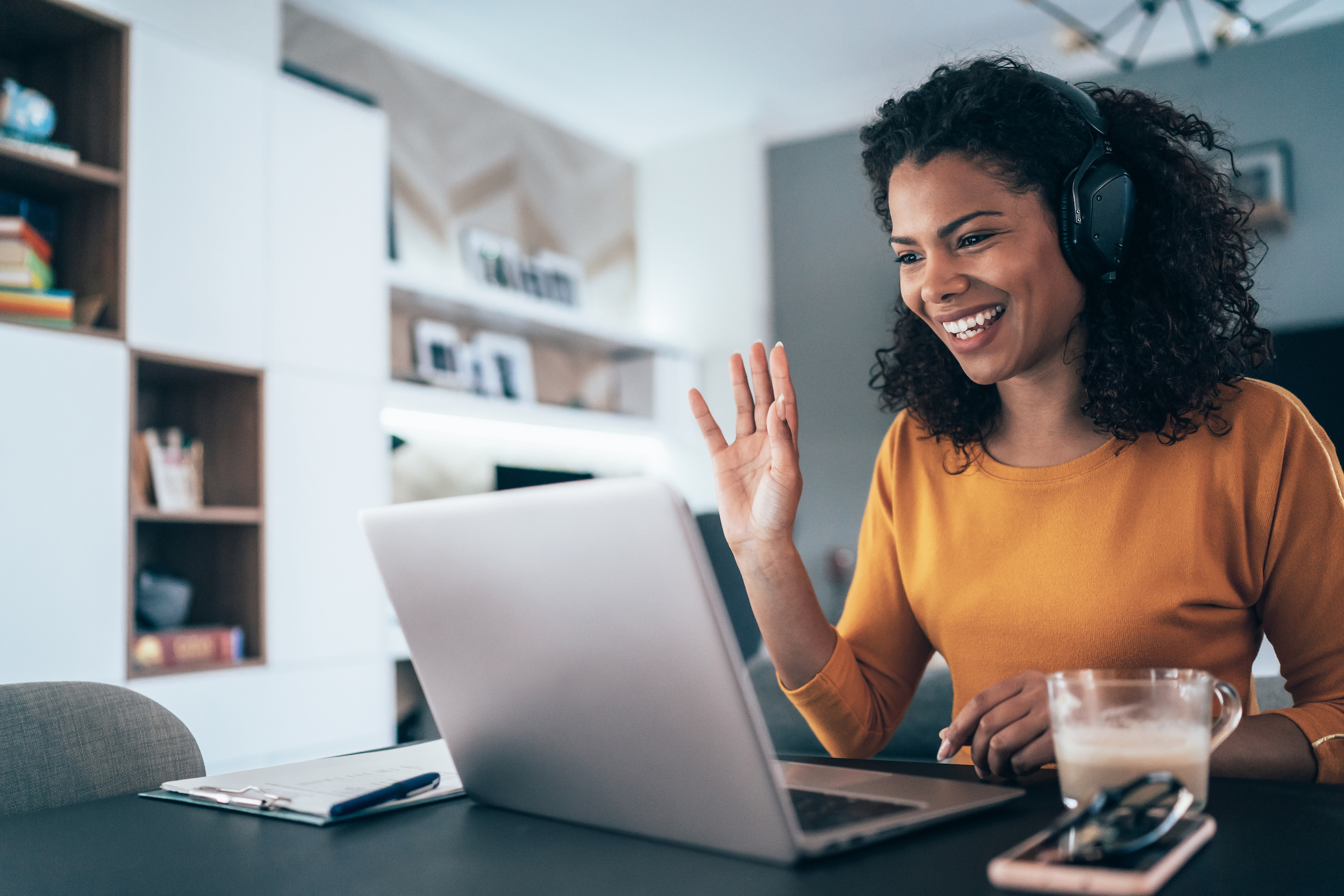 woman waving at laptop during meeting