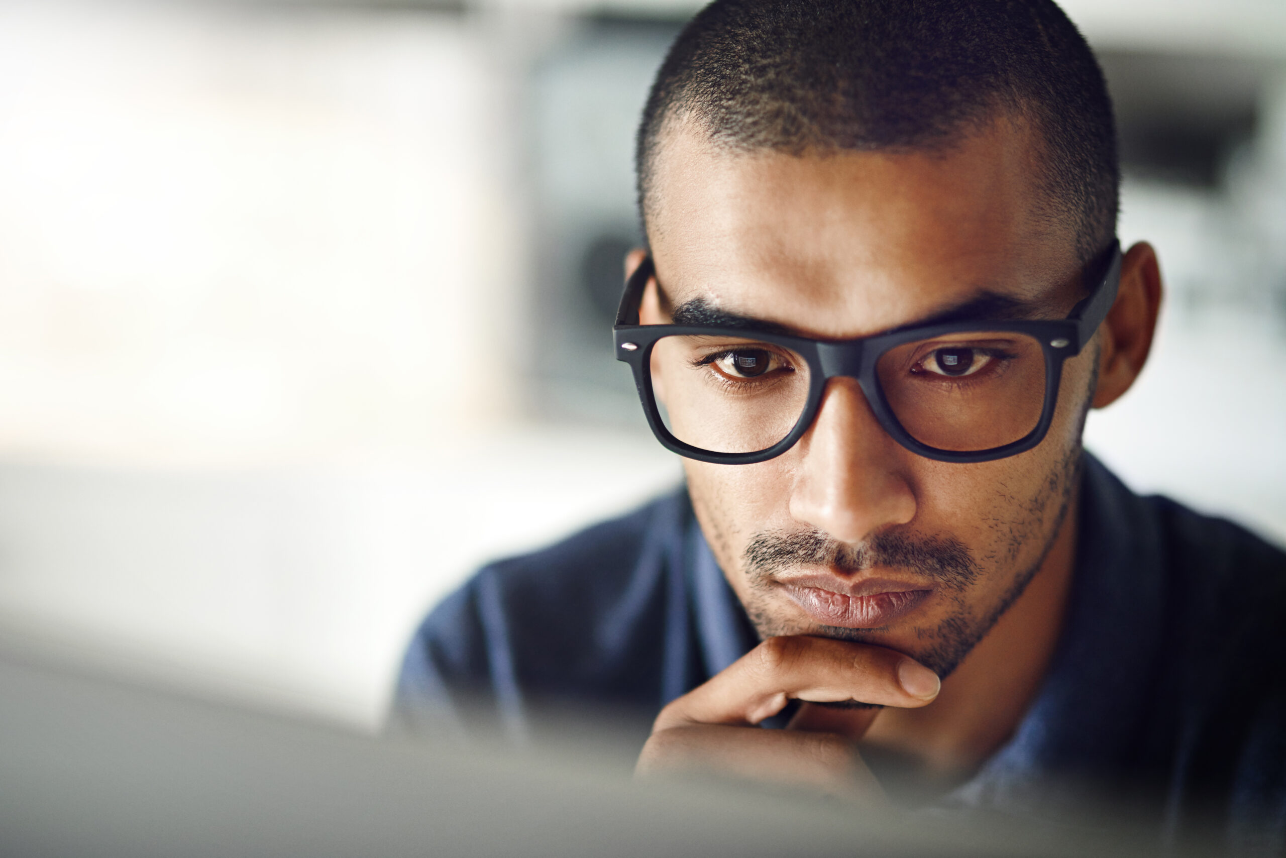 man with glasses studying psychology doctoral programs online