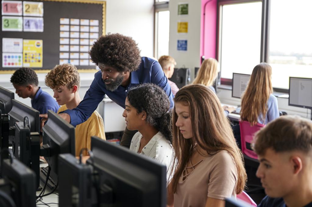 teacher with an arizona teaching certificate pointing at desktop for students