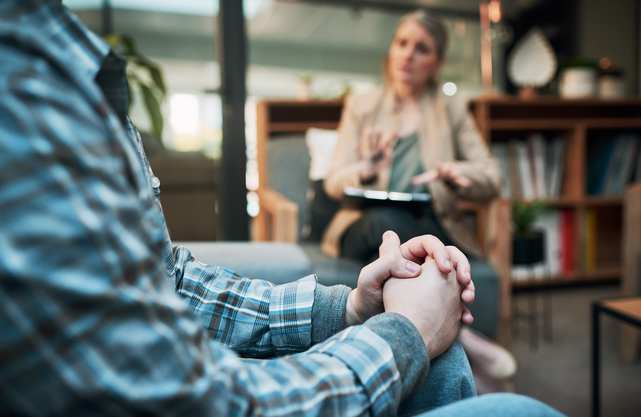 woman with a psychology certificate sitting with a patient in a therapy session