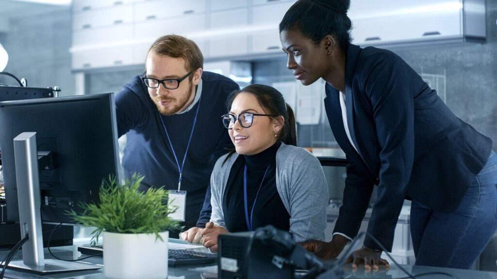 A group of people looking at a computer