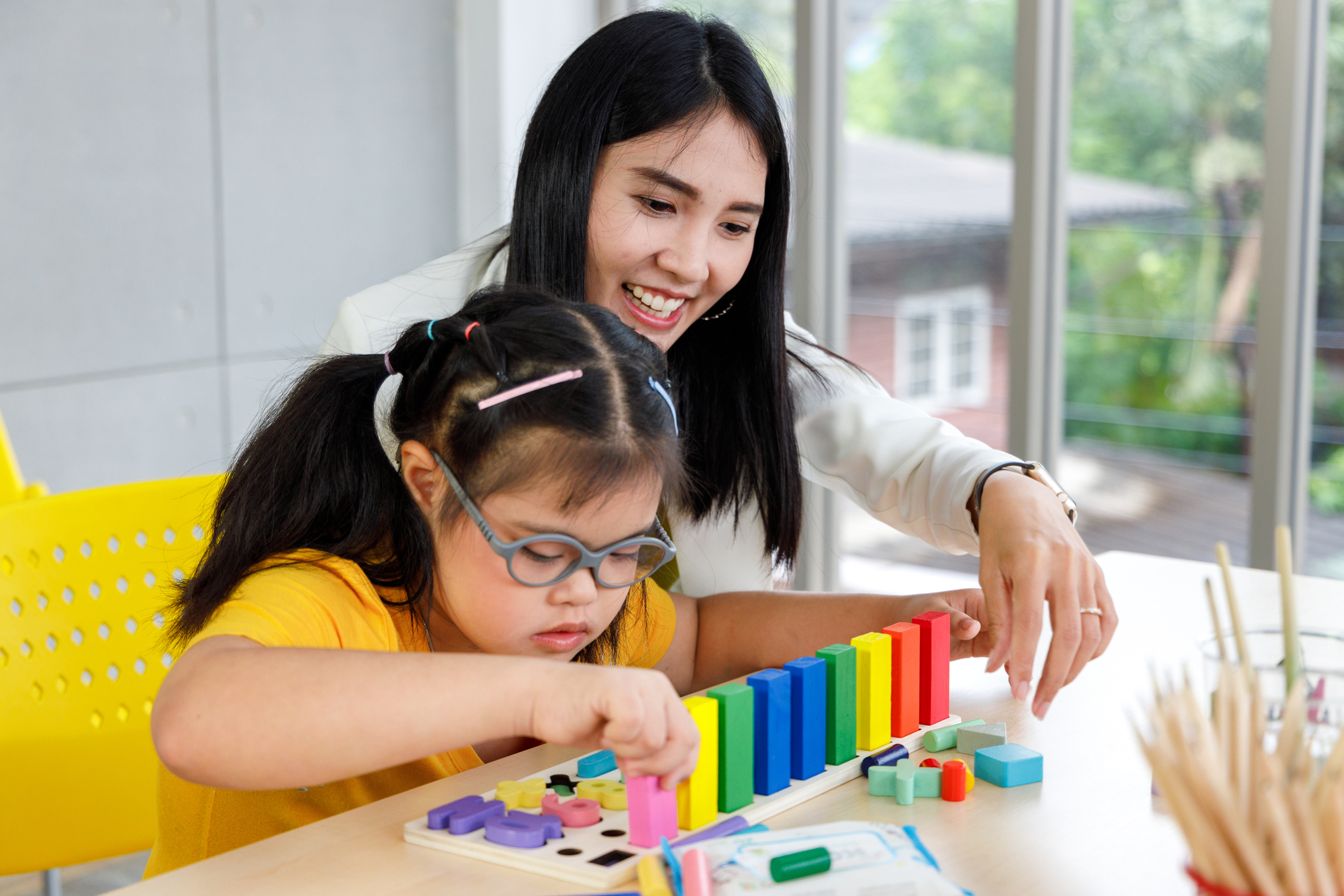 teacher helping student with blocks