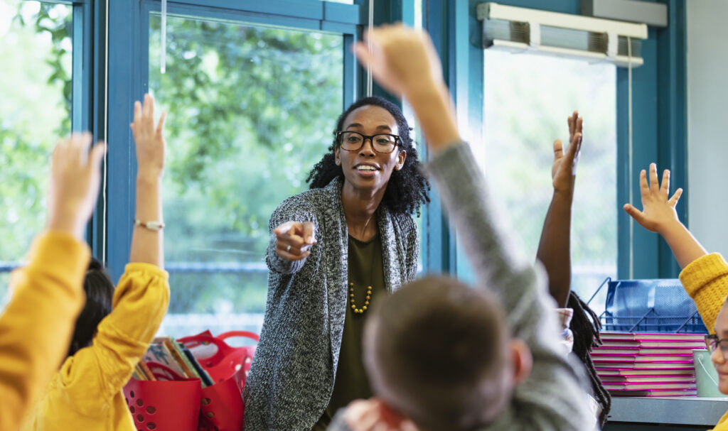 teacher pointing at student raising hands