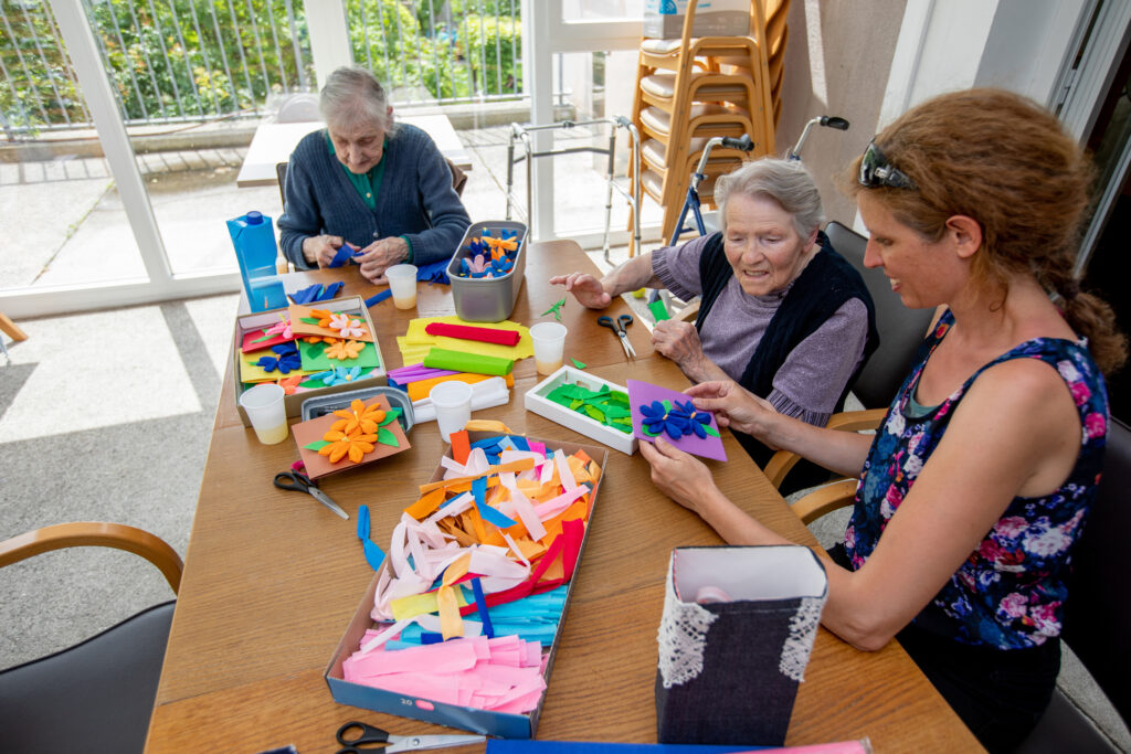 occupational therapist helping older woman with puzzles
