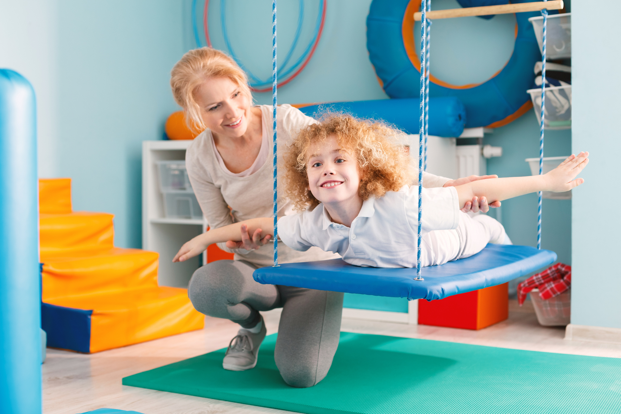 therapist helping child on swing