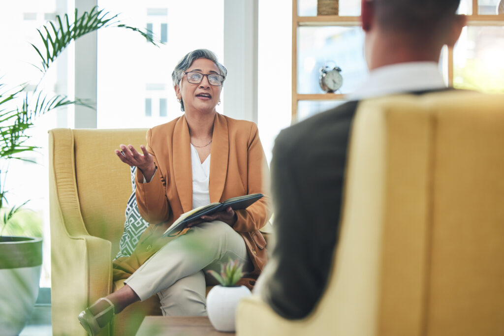 a female therapist is explaining the difference between LMFT and LMHC to a male client
