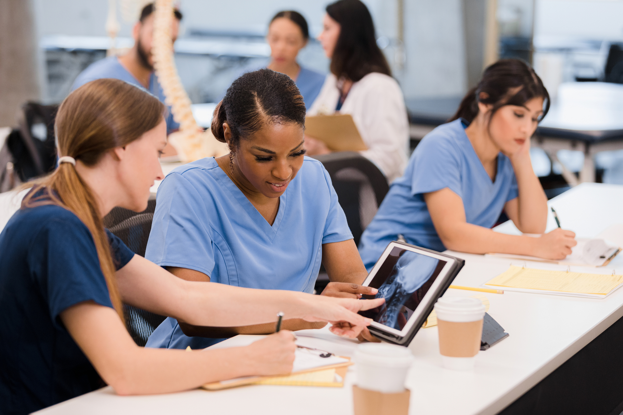 nurse talking to another nurse while showing tablet