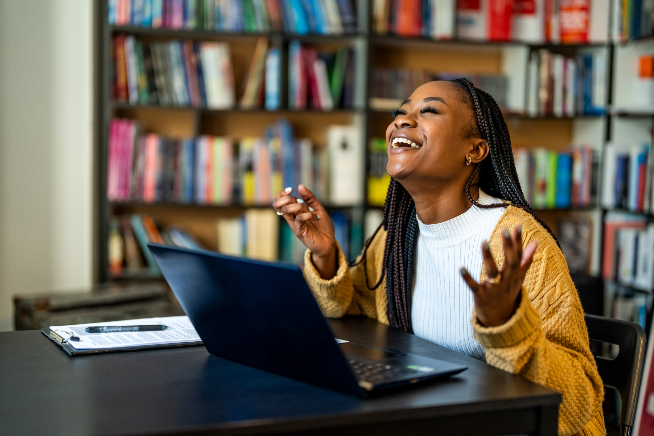 woman excited next to a laptop