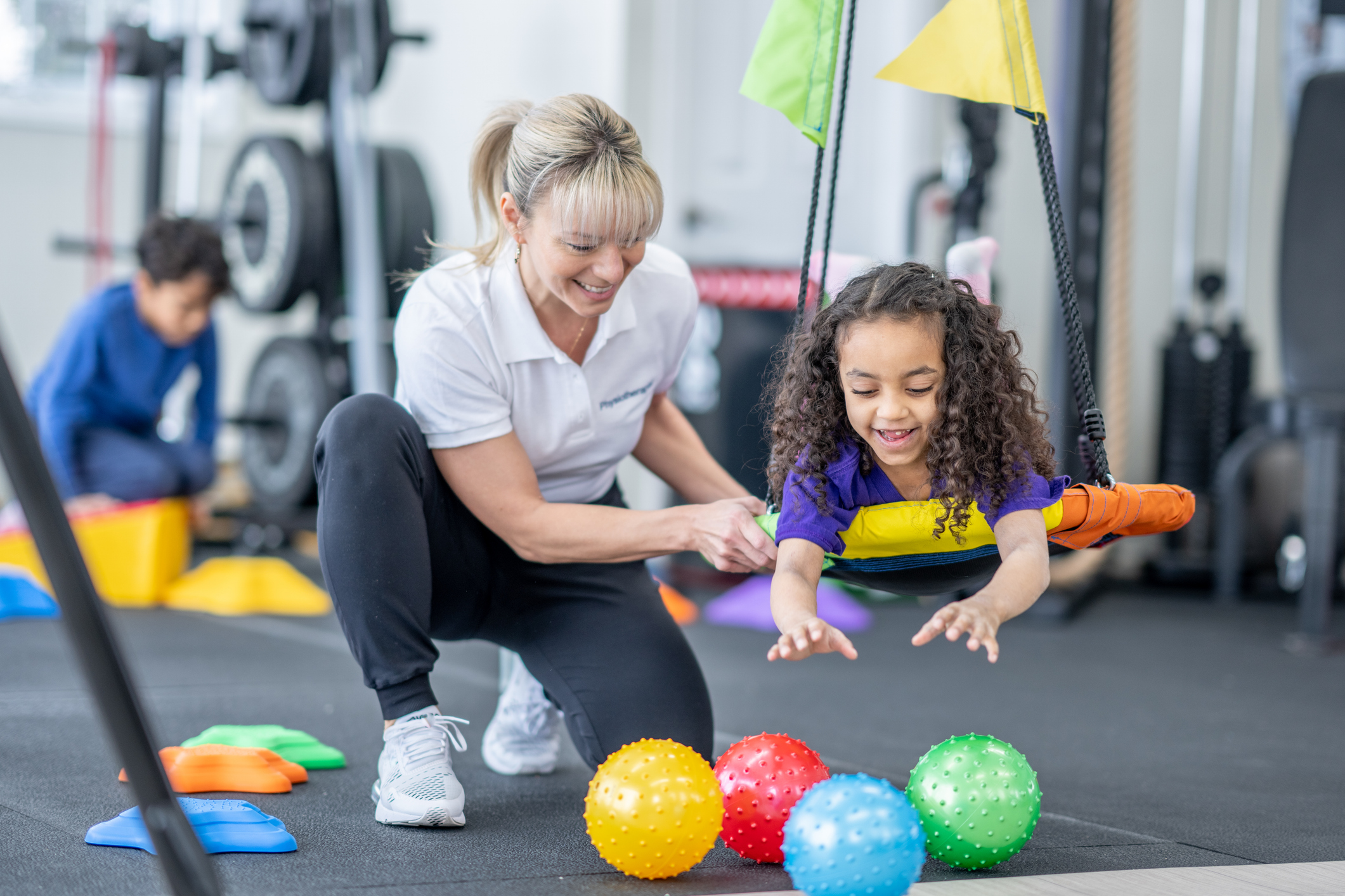 therapist helping child with reaching for balls