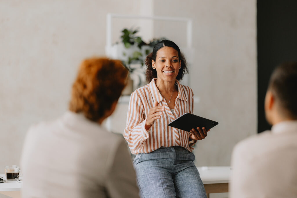 woman holding tablet talking to other business people