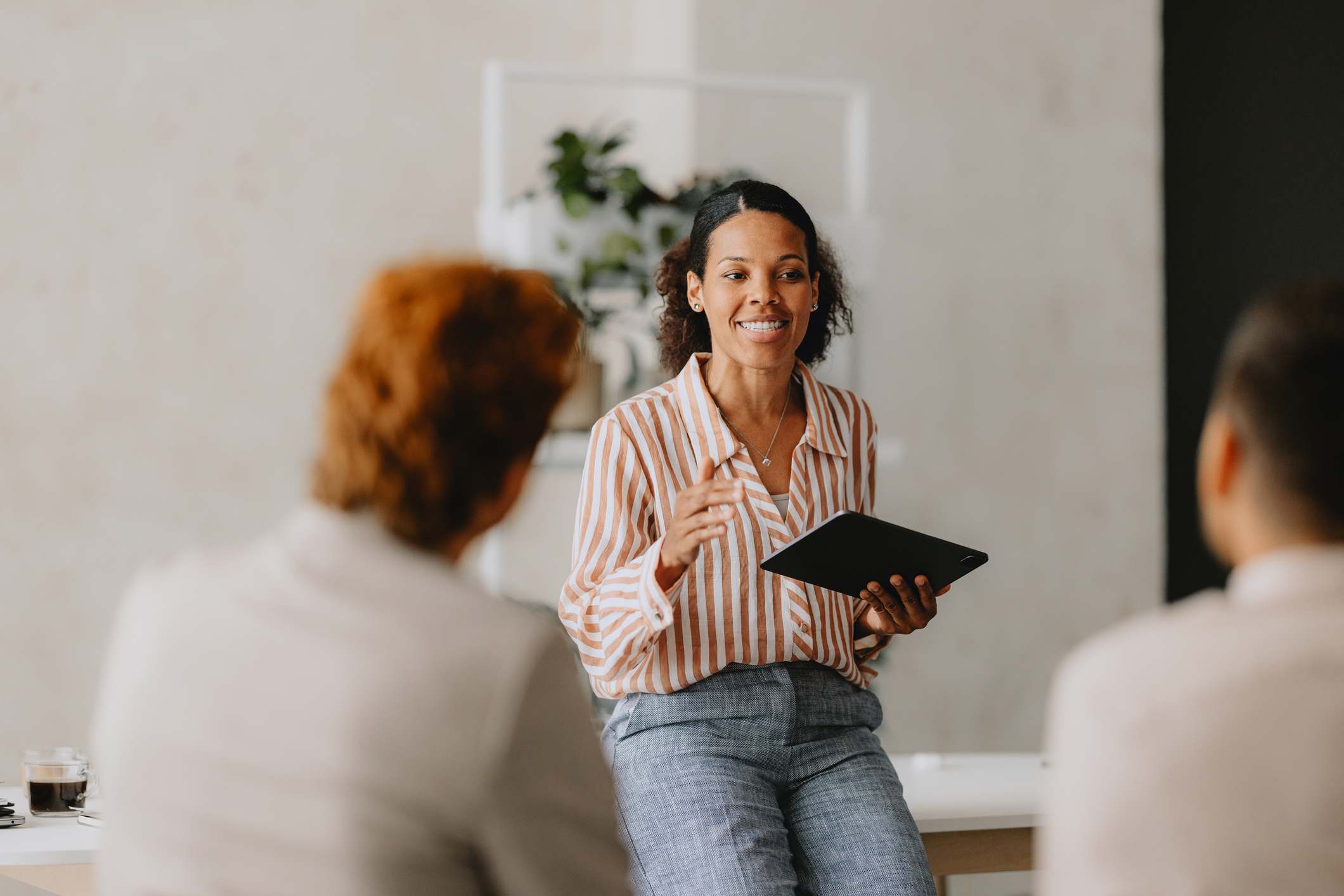 woman holding tablet talking to other business people
