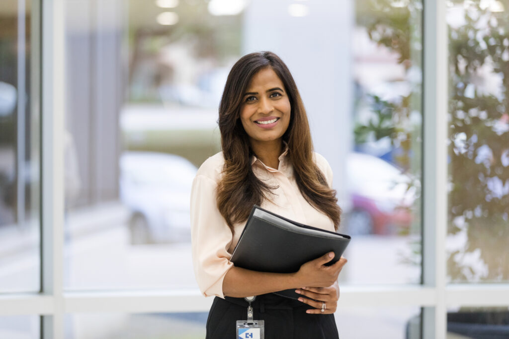 woman holding folders looking at camera