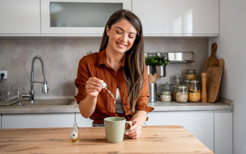 woman putting drops into a cup