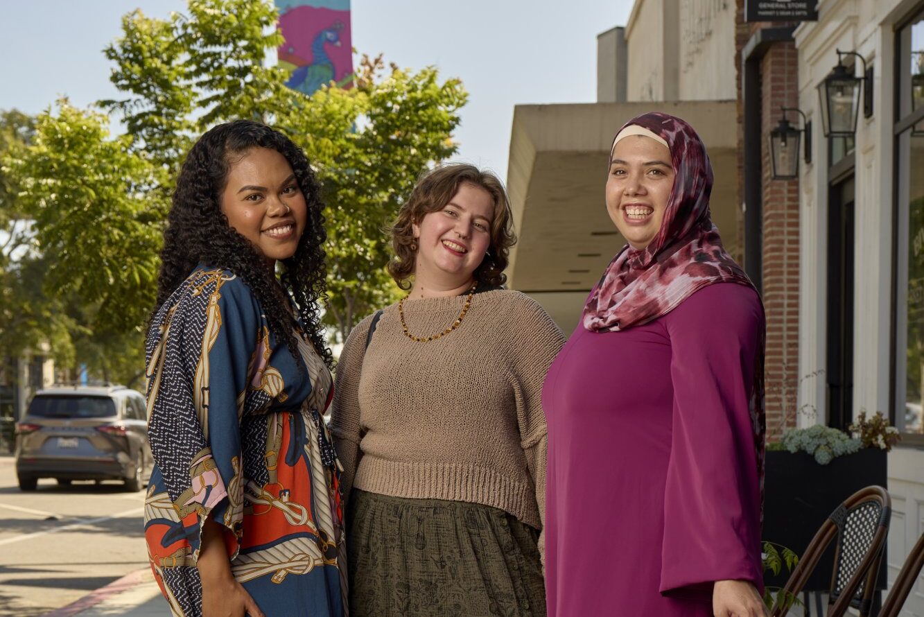 A group of women standing on a sidewalk