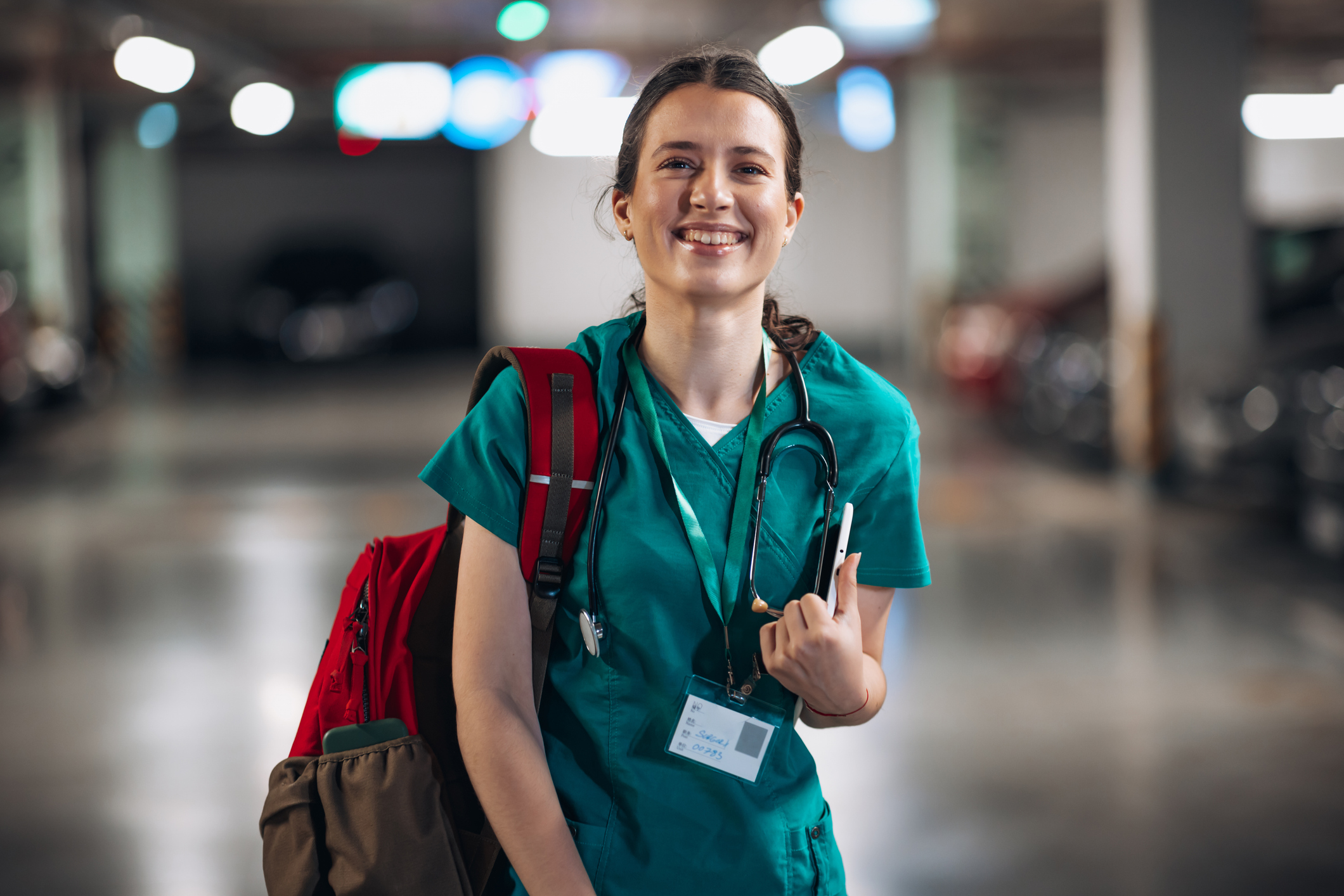 A woman wearing a scrubs and a backpack