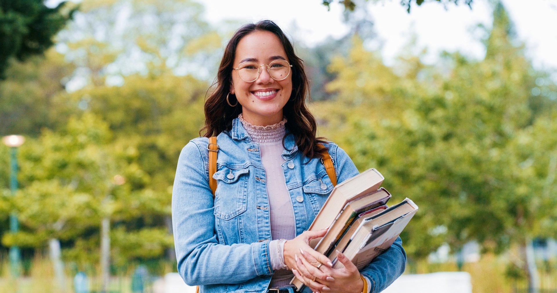 Woman, university student and books in portrait, outdoor and pride for learning, knowledge or happy in park. Girl, Japanese person and smile for scholarship, education and studying at college campus