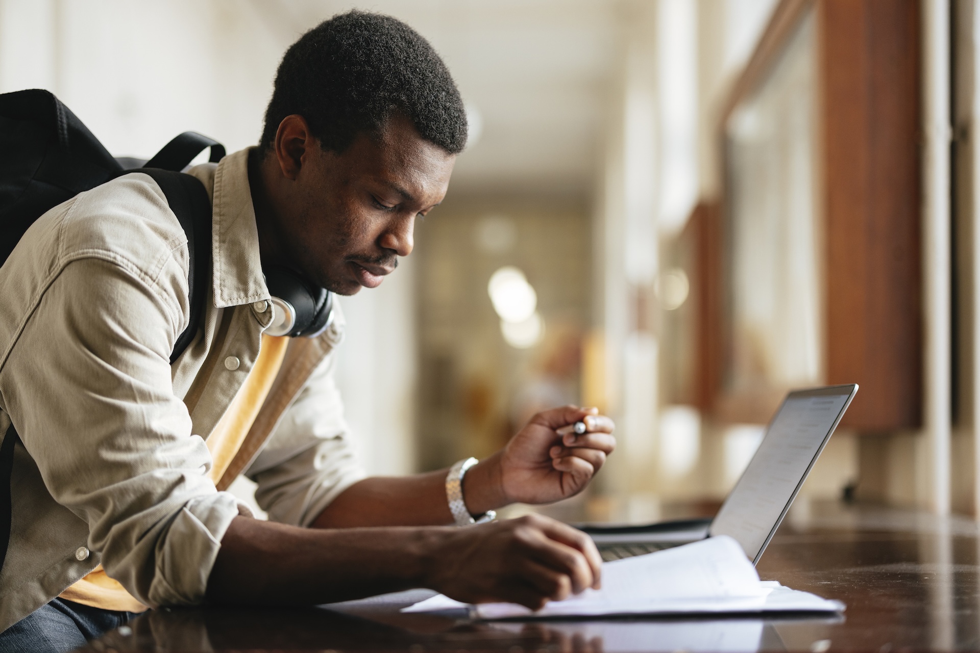 University Student Studying with Laptop in Bright Hallway