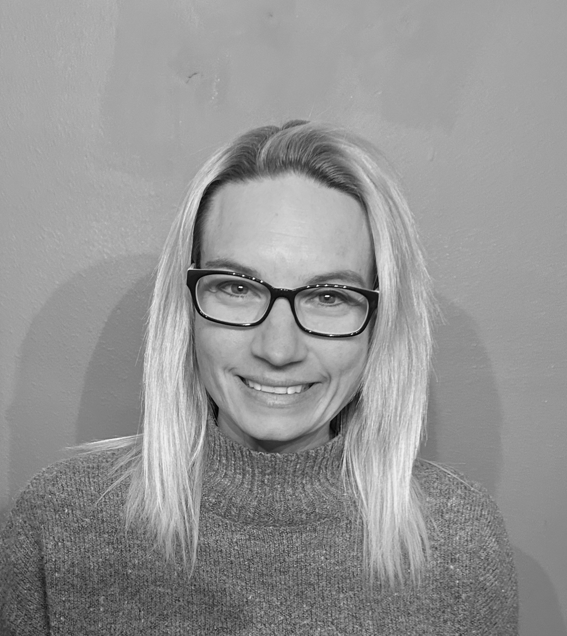 A woman wearing glasses and a sweater