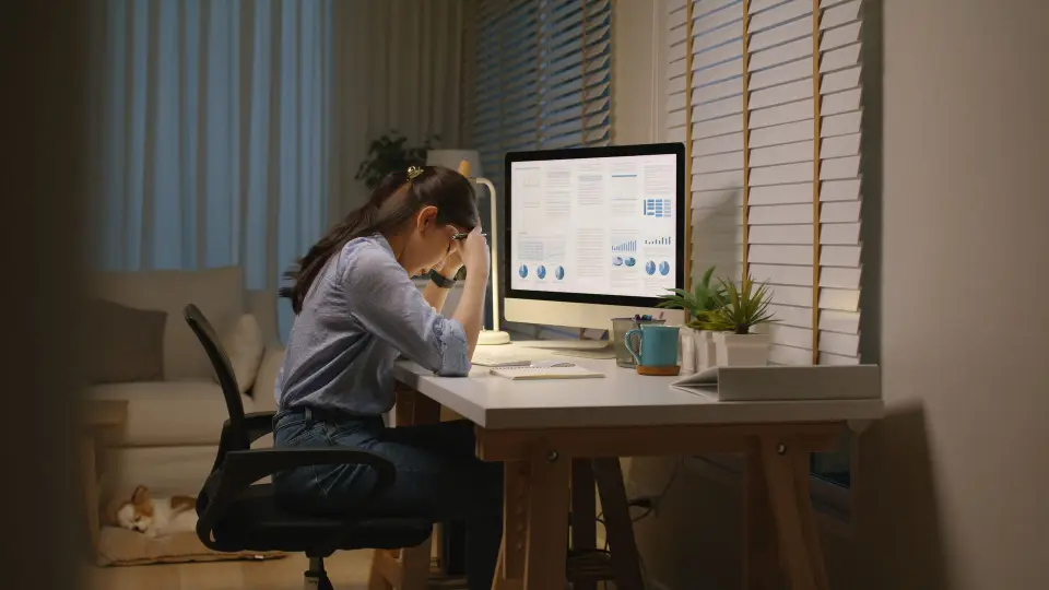 A woman sitting at a desk looking at a computer