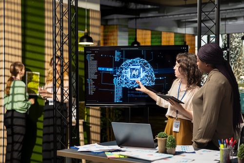 A group of people standing in front of a large screen