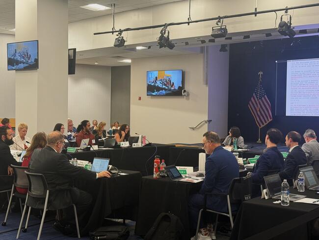 A group of people sitting at tables in a room with a television