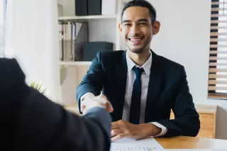 A man in a suit shaking hands with another man
