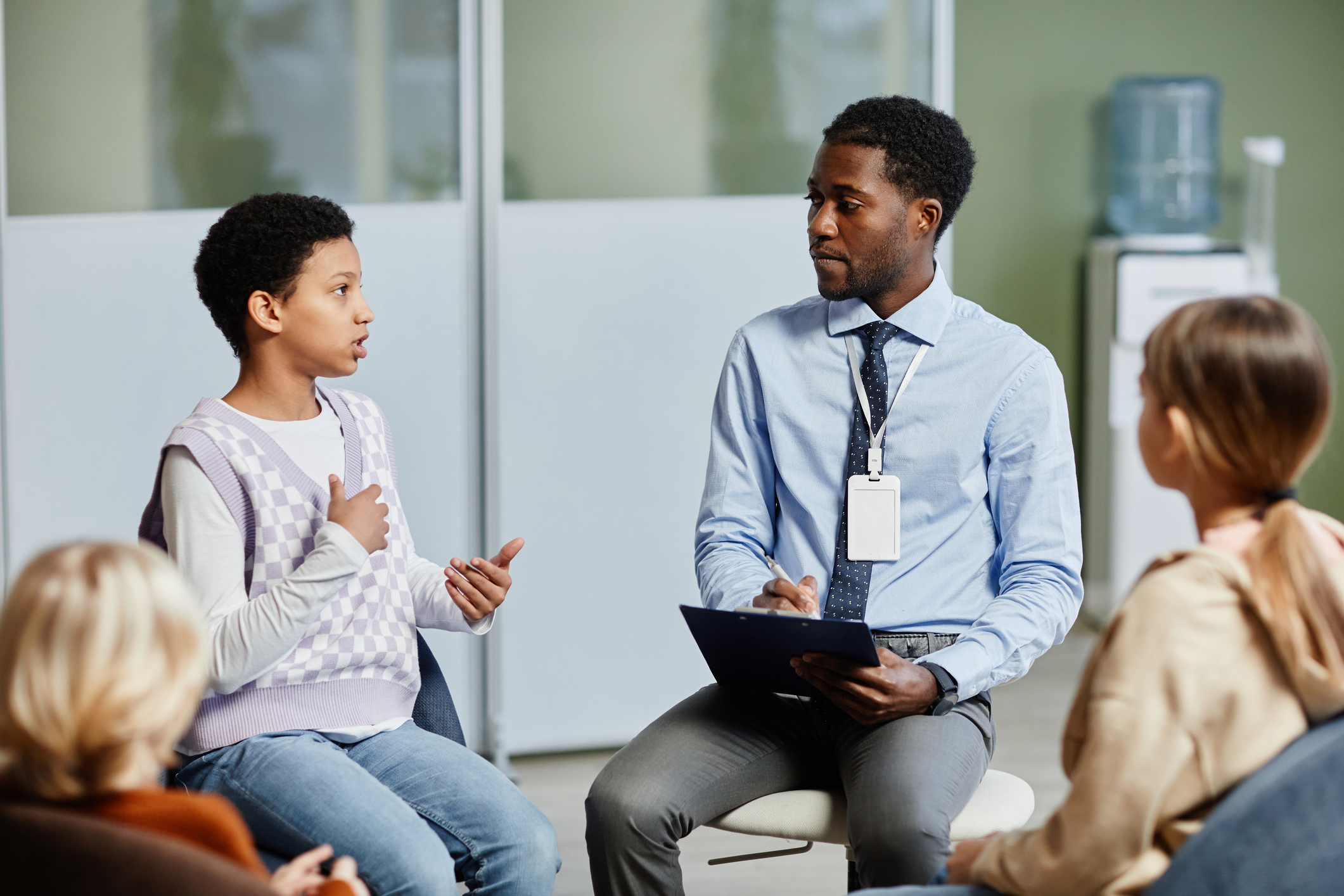 A man and boy sitting in a circle talking to each other