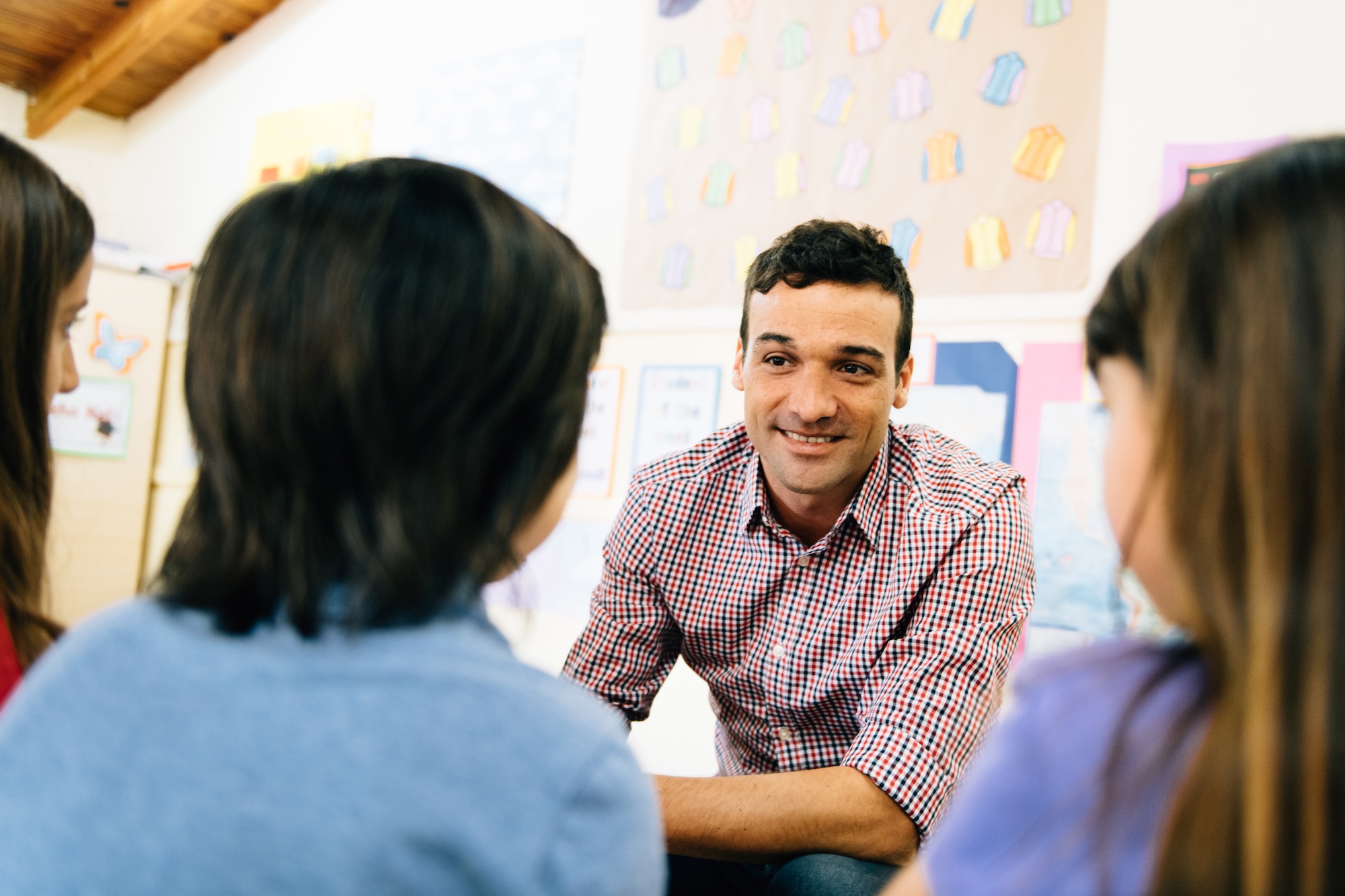 A man sitting in a circle with a group of children