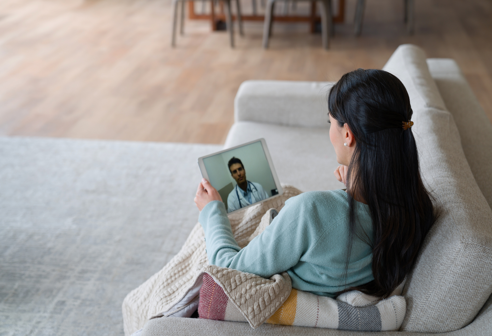 A woman sitting on a couch with a tablet
