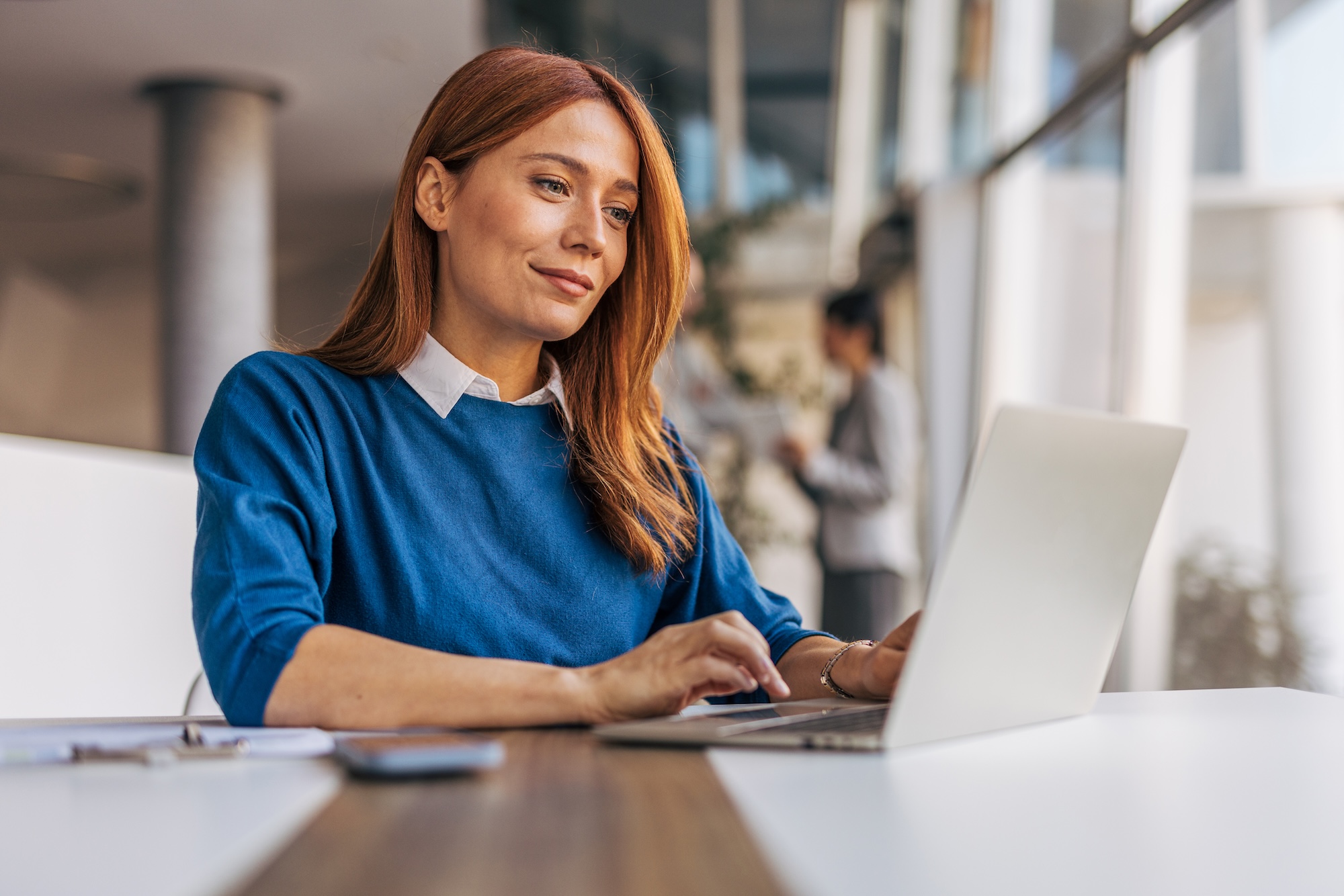 A woman sitting at a desk with a laptop
