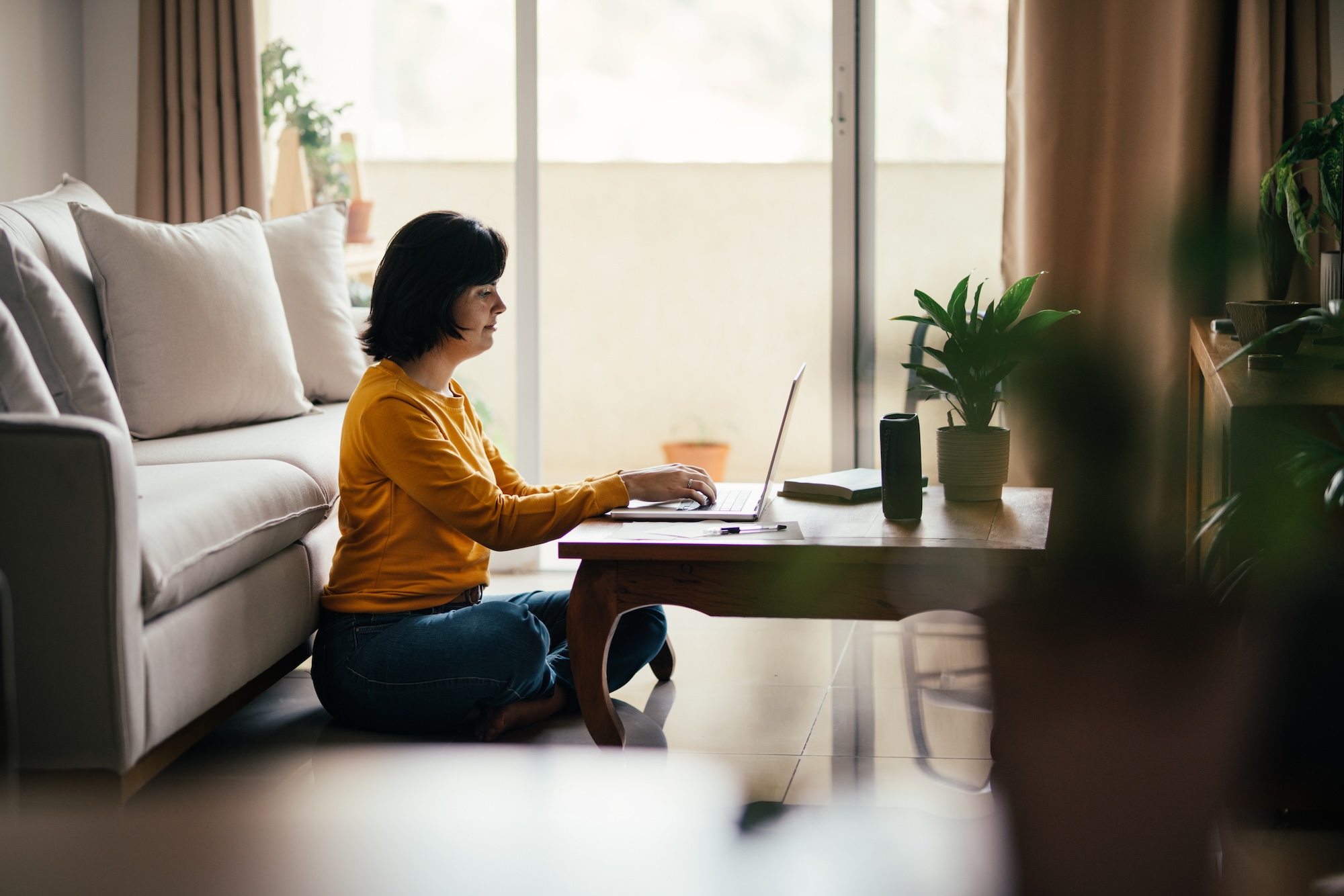 A woman sitting on the floor using a laptop