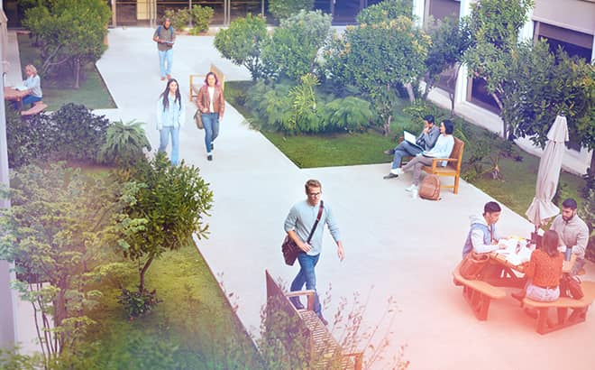 A group of people walking on a sidewalk